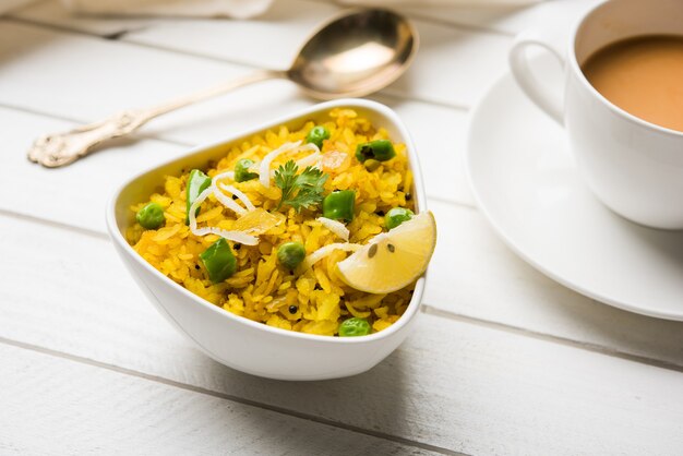 Indiase ontbijtschotel Poha Ook bekend als Pohe of Aalu poha bestaande uit geklopte rijst of afgeplatte rijst. De rijstvlokken zijn licht gebakken in olie met kruiden geserveerd met hete thee