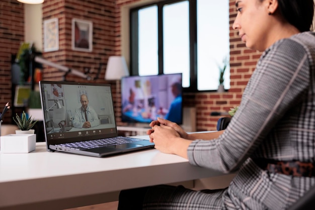 Indiase persoon die telegeneeskunde met videobellen gebruikt met een arts, een afspraak maakt voor de gezondheidszorg om te praten over behandeling en telegezondheid. Ontmoeting in online videoconferentie met arts om medicijnen te ontvangen.