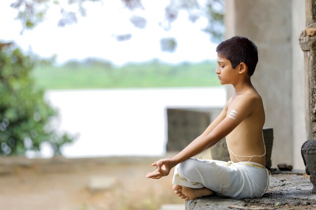 Indiase priester kind doet yoga in het park