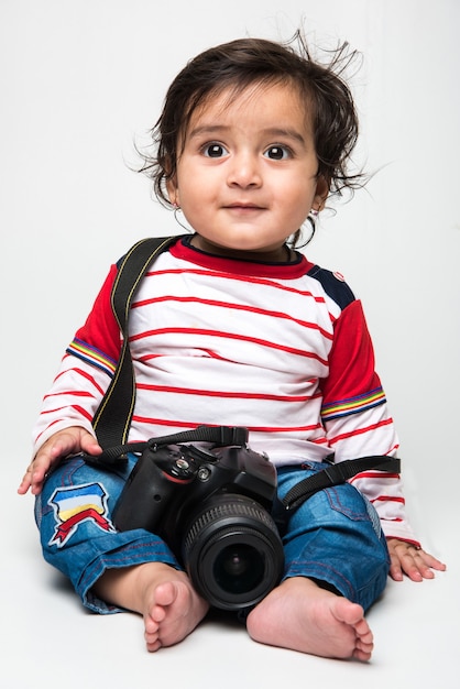 Indiase schattige kleine baby of baby of peuter met DSLR-camera, wil fotograaf worden