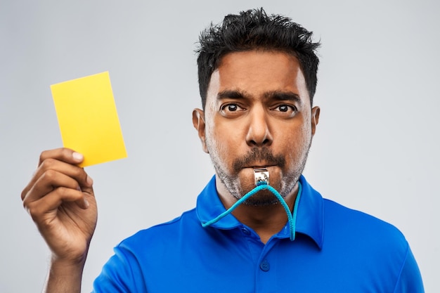 Indiase scheidsrechter fluit en toont geel kaartje.