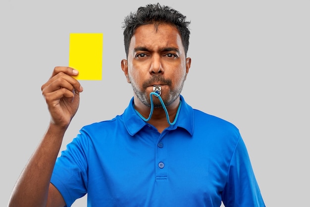Indiase scheidsrechter fluit en toont geel kaartje.