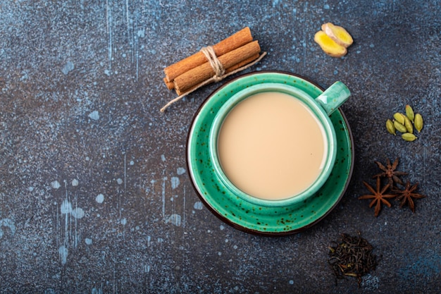 Indiase thee warme drank met melk en kruiden in rustiek groen