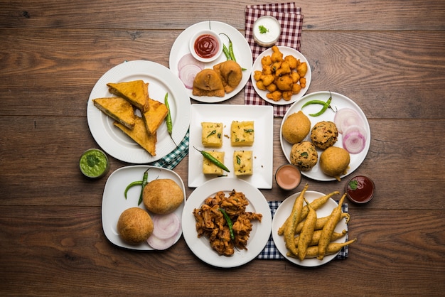 Indiase theetijdsnacks in groep omvatten Veg Samosa, Kachori, kachaudi, aloo bonda, khaman dhokla, brood, ui, chili en moong pakora, pakoda, bhaji, bhajji, Bhajiya, bajji met sauzen