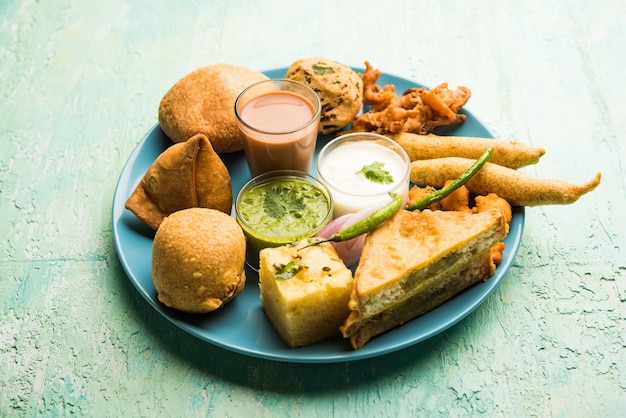 Indiase theetijdsnacks in groep omvatten veg samosa, kachori, kachaudi, aloo bonda, khaman dhokla, brood, ui, chili en moong pakora, pakoda, bhaji, bhajji, bhajiya, bajji met sauzen