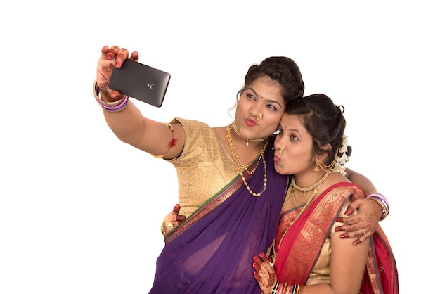 Indiase traditionele meisjes nemen selfie met smartphone op wit