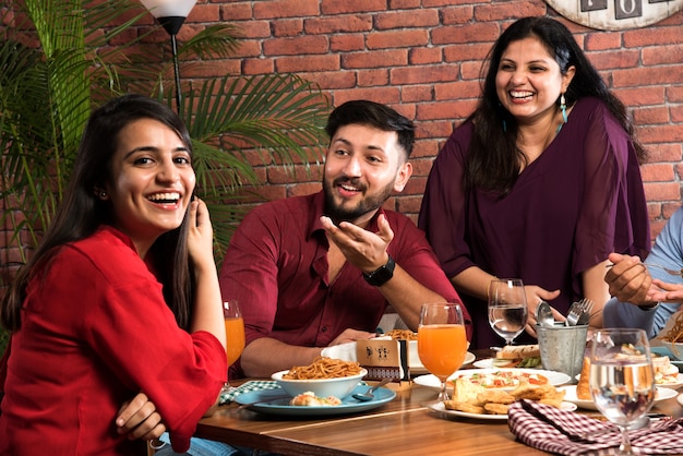 Indiase vrienden eten of dineren in restaurant. Aziatische mensen in het gezicht voor een bijeenkomst, reünie of feest. Coffeeshop Viering Vriendschap Saamhorigheid concept