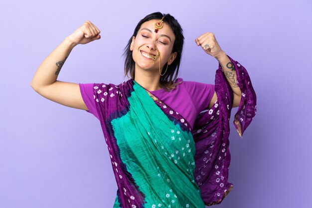 Indiase vrouw geïsoleerd op paars sterk gebaar doen