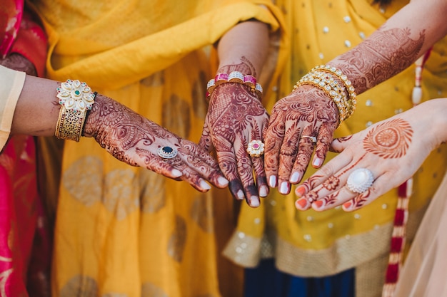 Indiase vrouw houdt haar handen bedekt met mehndi en draagt armbanden achter haar borst