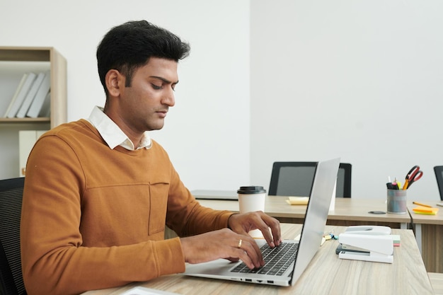 Indiase zakenman die op laptop werkt