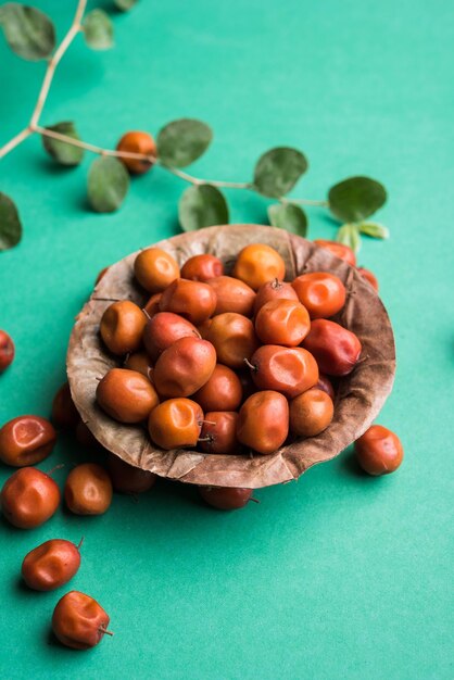 Indiase zoete Jujube of ber of berry of Ziziphus mauritiana, in een kom of op een witte achtergrond