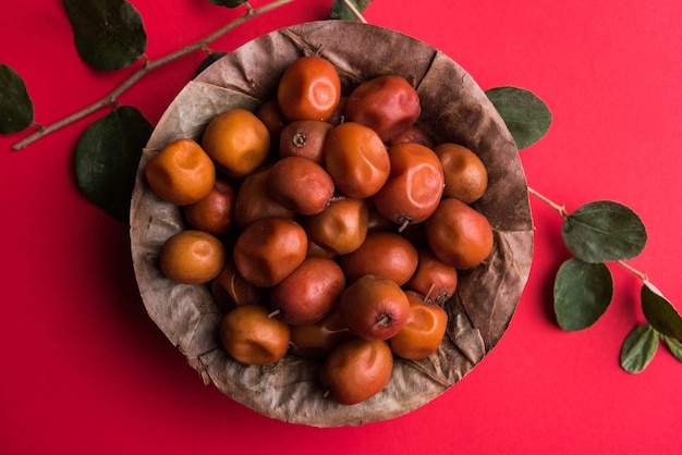 Indiase zoete Jujube of ber of berry of Ziziphus mauritiana, in een kom of op een witte achtergrond