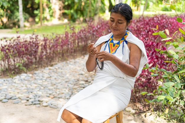 Indigenous woman in traditional clothing weaving