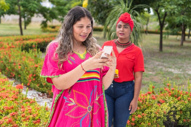 携帯電話を使って友人を待っている先住民族の女性