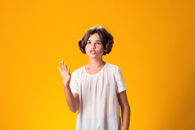 Indignant angry expressive confused kid girl over yellow background Emotion concept