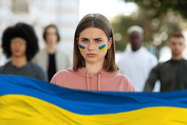 Возмущенная дама, стоящая над многорасовой группой студентов, поддерживающих Украину