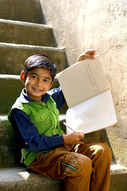 Indisch kind dat op notaboek schrijft