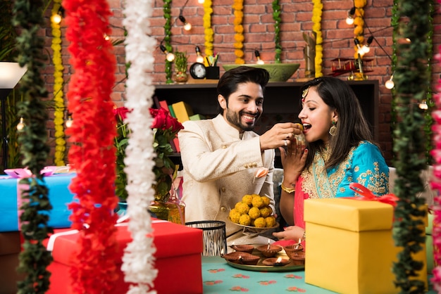 Indisch slim stel dat zoete laddu eet op Diwali of jubileum, selectieve focus