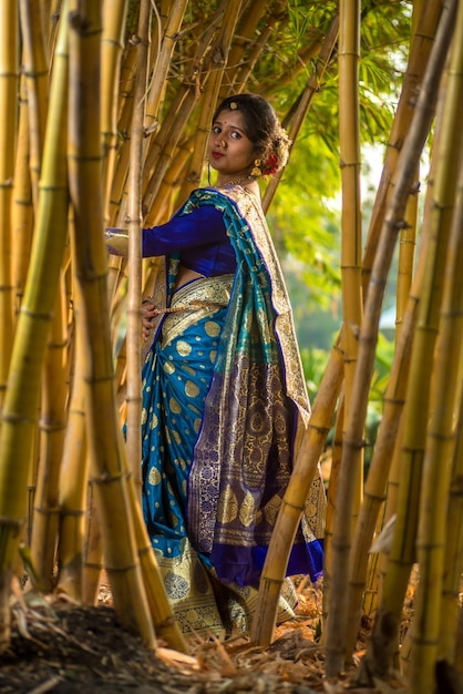 Foto indisch traditioneel mooi jong meisje in saree poseert buiten in het park