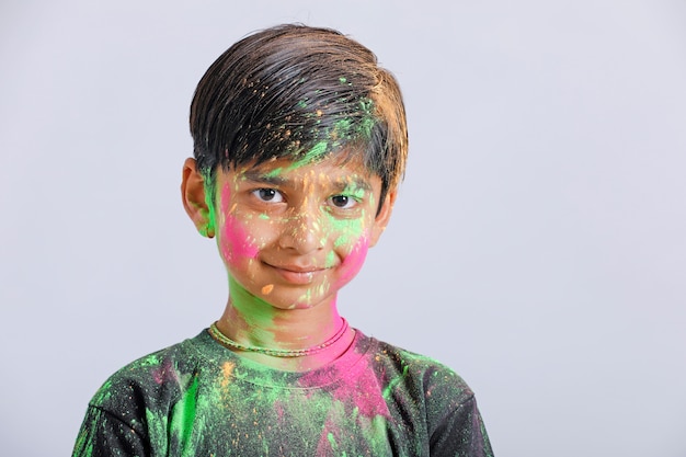 Indische kleine jongen die met de kleur in holifestival speelt