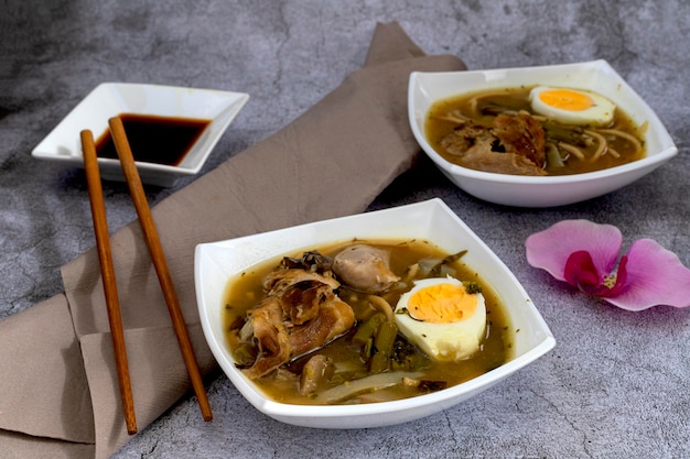 Individual bowls of Ramen oriental soup on gray stone background