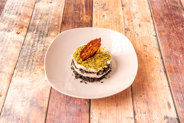 Individual carrot cake with pistachios black sponge cake and biscuit crunch