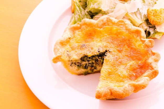 Individual spinach quiche served with salad.