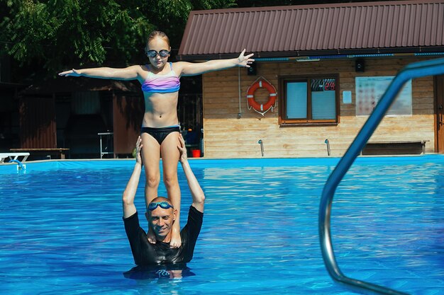 Individual swimming lesson with a child in an outdoor pool,
diving