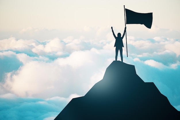 An individual with an outstretched arm holds a flag on the summit of a mountain above the clouds denoting success and conquest