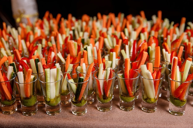 Individuele Cocktail borrelglaasjes met stokjes wortel, komkommer en pikante saus.