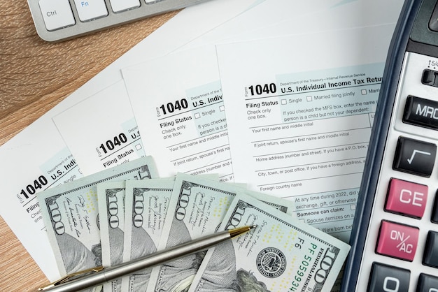 Individuele inkomstenbelasting aangifte 1040 wirh dollar contant pen en rekenmachine op kantoor bureau
