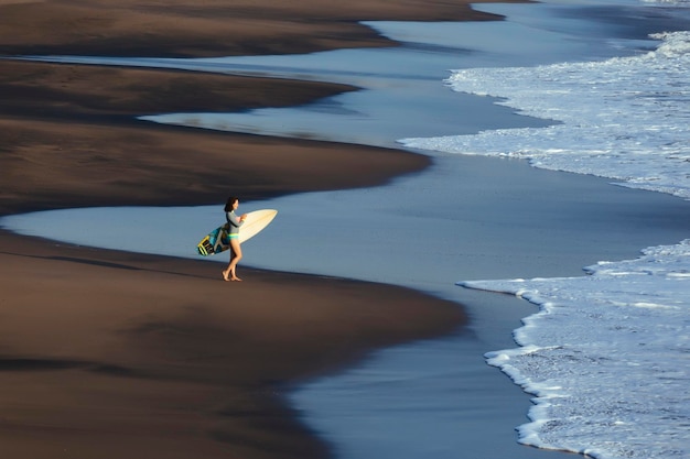 Indonesia, Bali, young woman with surfboard