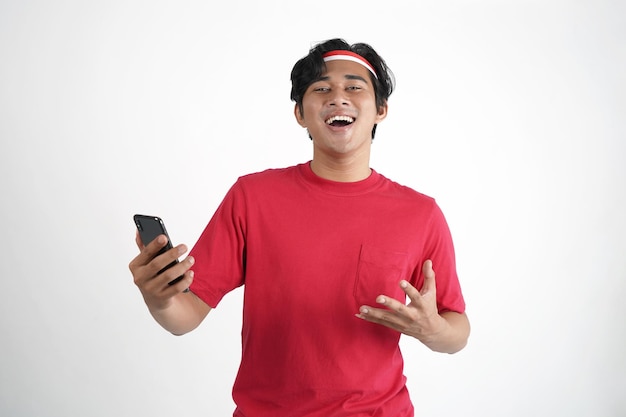 Indonesia Independence Day Concept. Indonesian Man looking at mobile phone with surprise expression