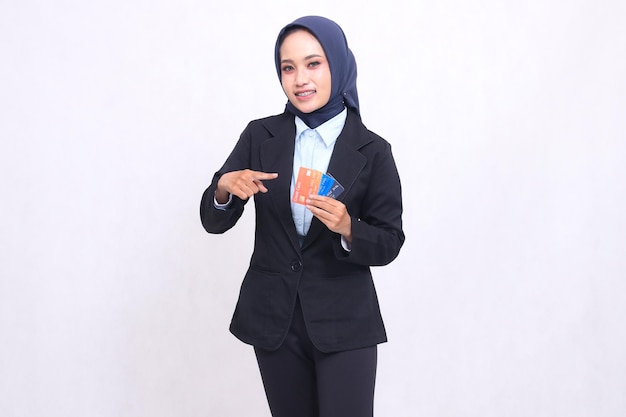 indonesia mature office woman in hijab standing cheerfully showing and carrying credit debit card fo