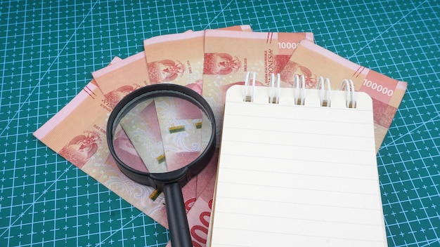 Indonesia Money Indonesian currency with magnifying glass and book