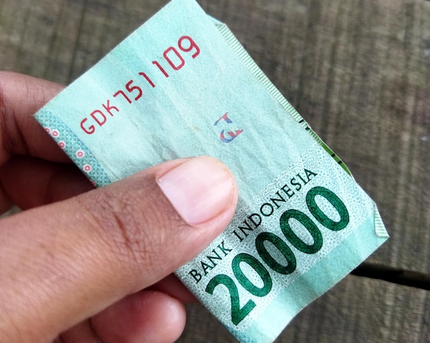 Indonesia money twenty hundred rupiah take by hand