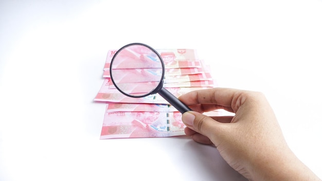 Indonesia Rupiah banknote with magnifying glass finance and business concept