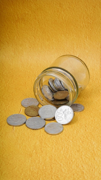 Indonesian Coins Spilling from Glass Jar selective focus