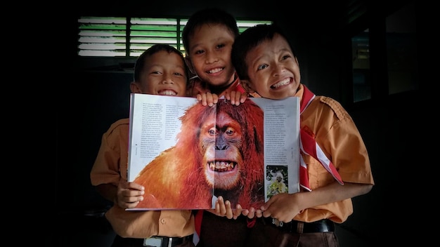 Photo indonesian elementary school children with an encyclopedia