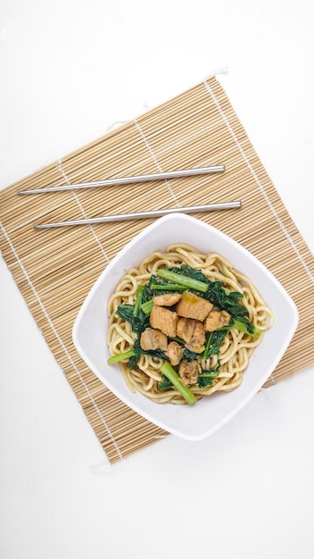 Indonesian food Mie Ayam or Bami ayam noodles with chicken and served on white bowl