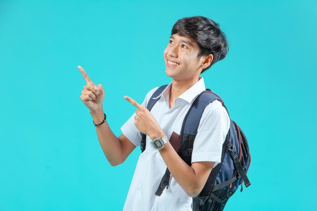 Indonesian male high school students wearing gray and white
uniforms isolated on a blue background