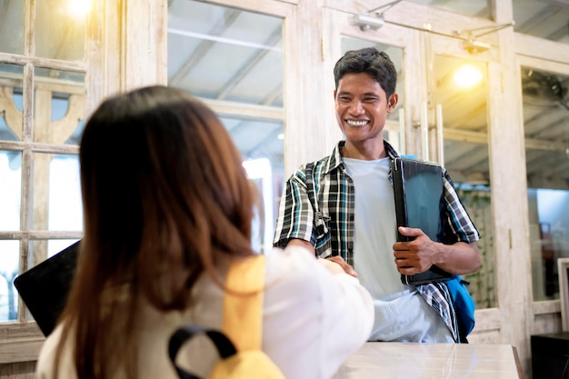 Indonesian male office worker handshake with female client on a meeting in modern workplace start up company