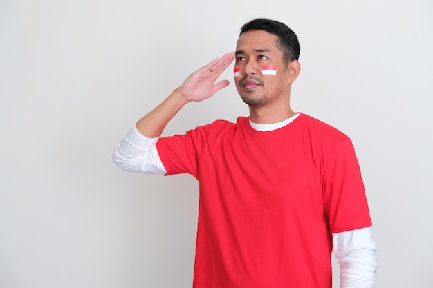 Indonesian man looking far away while give salute with proud gesture