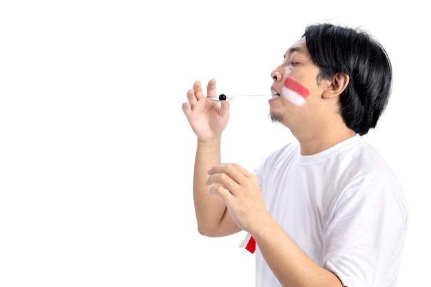 Indonesian men celebrate Indonesian independence day on 17 August with a marbles race using a spoon isolated over white background