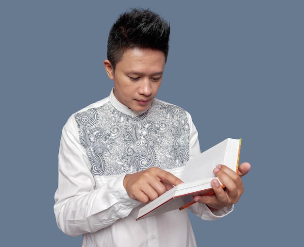 Indonesian muslim man was holding and reading Al Quran