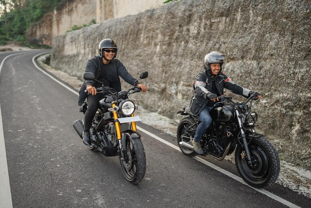 Indonesian riders on jacket and helmet traveling on the street by motorbike