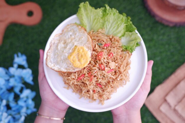 Photo indonesian spicy noodles with egg on white plate stock photo