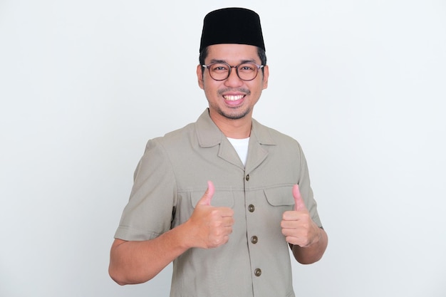 Indonesian teacher smiling at camera while giving two thumbs up