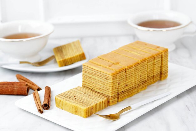 Indonesian Thousand Layer Cake or Lapis Legit Usually Served on Lebaran Natal and Imlek Served with Tea White Background Bakery Concept