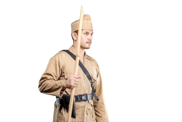 indonesian warrior standing while holding sharpened bamboo stick